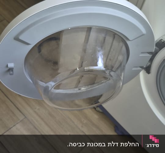 דלת מכונת כביסה פתוחה בחדר אמבטיה